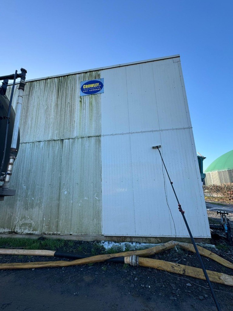 Industrial cladding half-cleaned, green algae on the left and bright white on the right